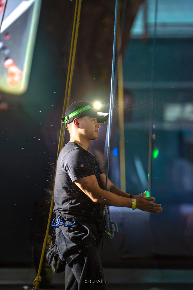A stage performer with juggling props beneath coloured lights